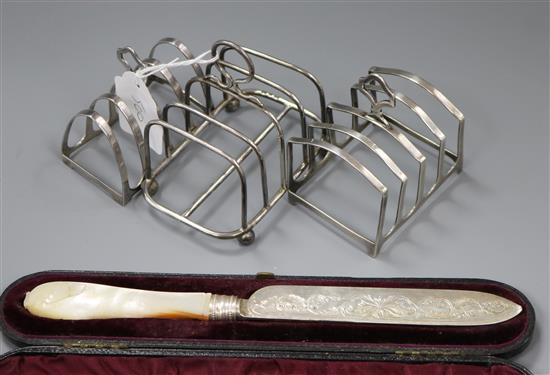 Three silver toastracks and cased Victorian silver and mother of pearl handled knife.